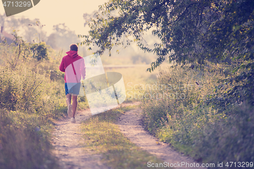 Image of man jogging along a country road