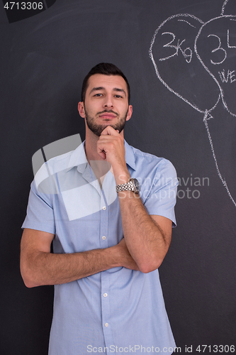 Image of portrait of man in front of black chalkboard