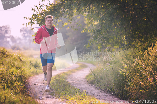 Image of man jogging along a country road