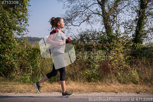 Image of woman jogging along a country road