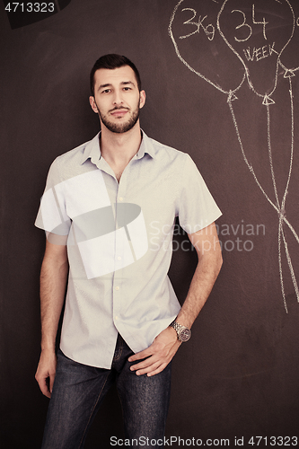 Image of portrait of man in front of black chalkboard