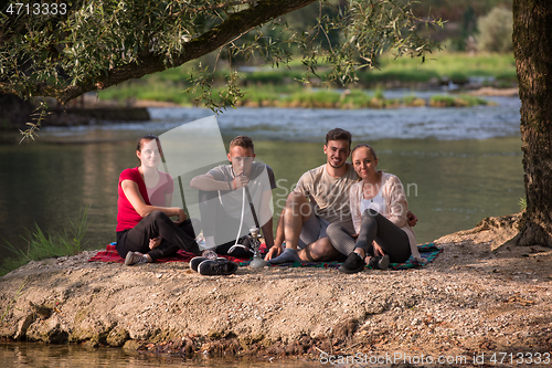 Image of friends smoking hookah on the river bank