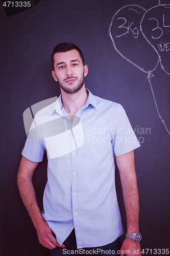 Image of portrait of man in front of black chalkboard