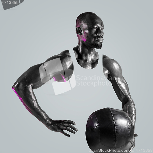 Image of Young african-american bodybuilder training over gray background
