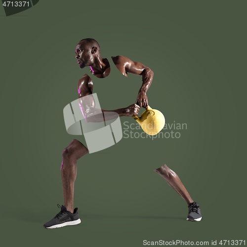 Image of Young african-american bodybuilder training over green background