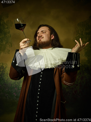 Image of Young man as a medieval knight on dark background