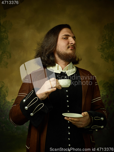 Image of Young man as a medieval knight on dark background