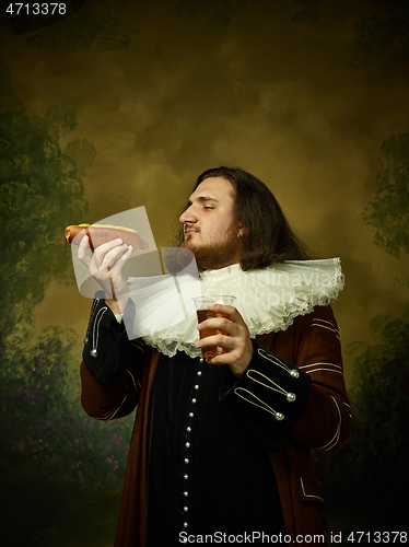 Image of Young man as a medieval knight on dark background