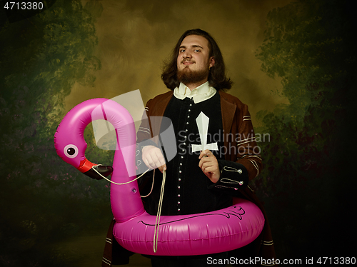 Image of Young man as a medieval knight on dark background