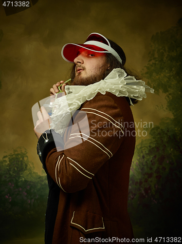 Image of Young man as a medieval knight on dark background