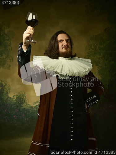 Image of Young man as a medieval knight on dark background