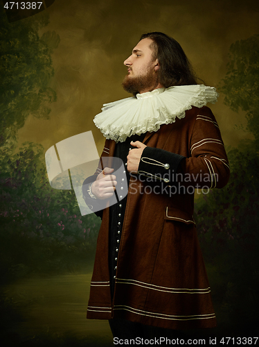 Image of Young man as a medieval knight on dark background