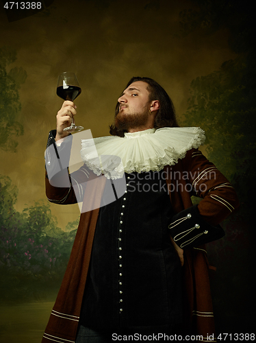 Image of Young man as a medieval knight on dark background