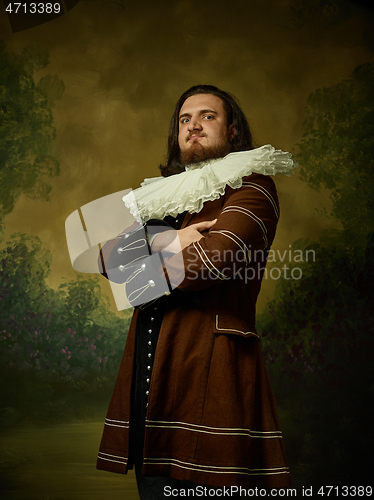 Image of Young man as a medieval knight on dark background