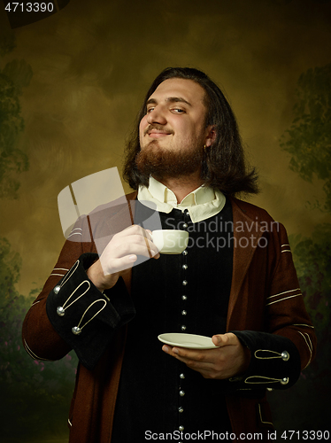 Image of Young man as a medieval knight on dark background