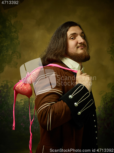 Image of Young man as a medieval knight on dark background