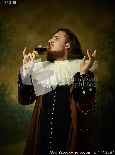 Image of Young man as a medieval knight on dark background