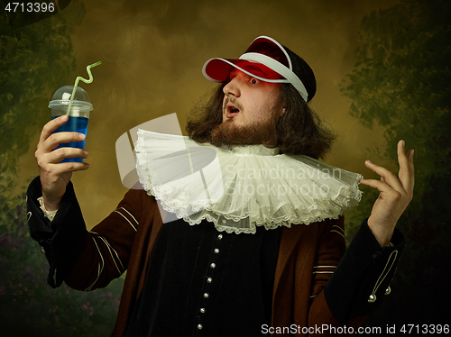 Image of Young man as a medieval knight on dark background