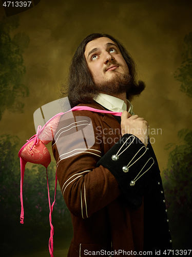 Image of Young man as a medieval knight on dark background