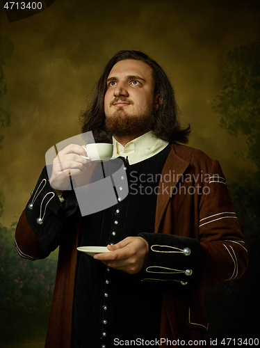 Image of Young man as a medieval knight on dark background