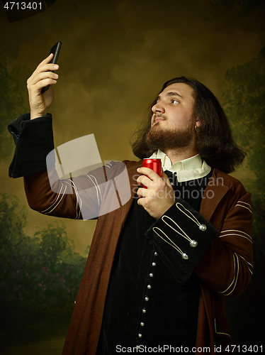 Image of Young man as a medieval knight on dark background