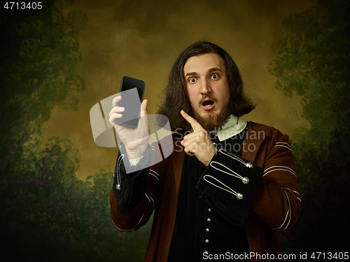 Image of Young man as a medieval knight on dark background