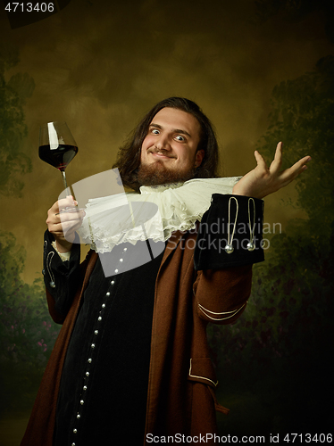 Image of Young man as a medieval knight on dark background