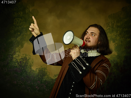 Image of Young man as a medieval knight on dark background