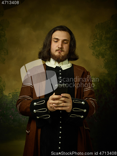 Image of Young man as a medieval knight on dark background