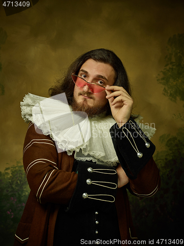 Image of Young man as a medieval knight on dark background