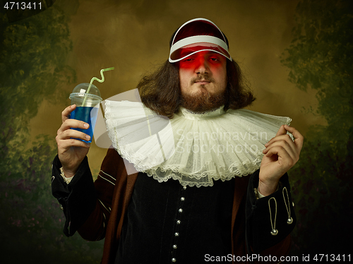 Image of Young man as a medieval knight on dark background