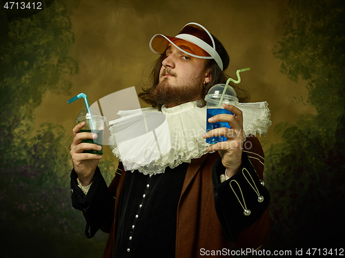 Image of Young man as a medieval knight on dark background