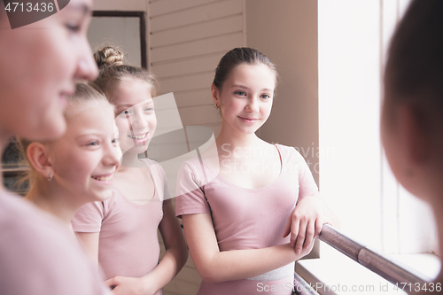 Image of Young graceful female ballet dancers dancing at training studio