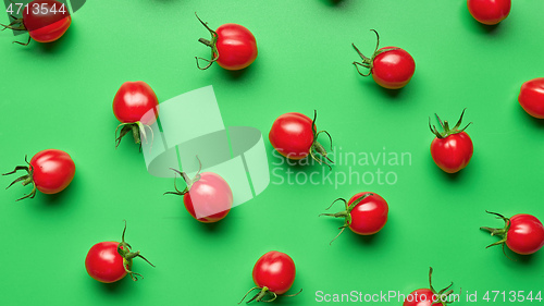 Image of red cherry tomatoes on green background