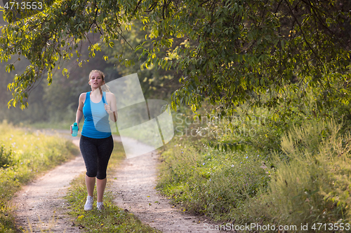 Image of woman jogging along a country road