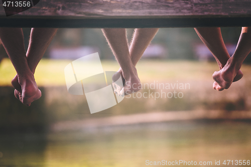 Image of people sitting at wooden bridge