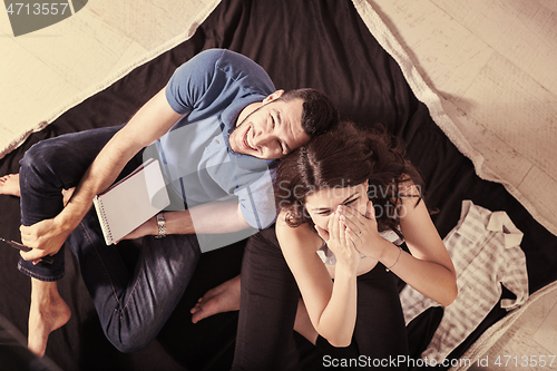 Image of top view of couple checking a list of things for their unborn ba