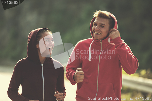 Image of young couple jogging along a country road