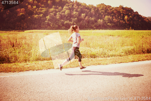 Image of woman jogging along a country road