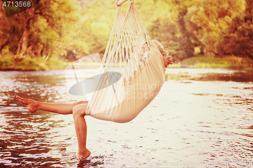 Image of blonde woman resting on hammock