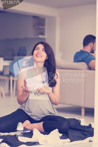 Image of pregnant couple checking a list of things for their unborn baby