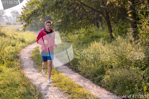 Image of man jogging along a country road