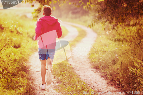 Image of man jogging along a country road