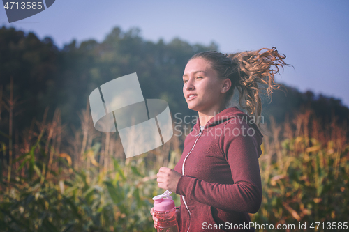 Image of woman jogging along a country road