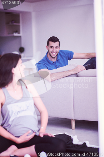 Image of pregnant couple checking a list of things for their unborn baby