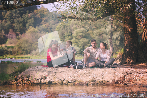 Image of friends smoking hookah on the river bank