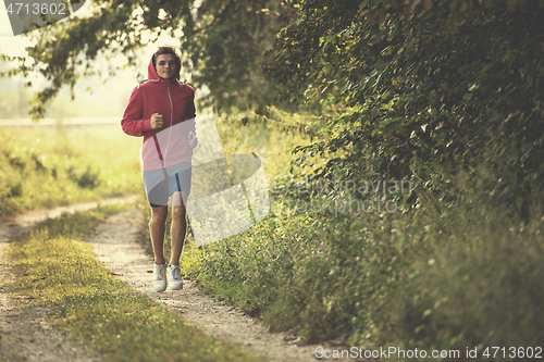 Image of man jogging along a country road