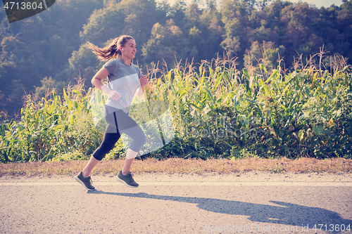 Image of woman jogging along a country road