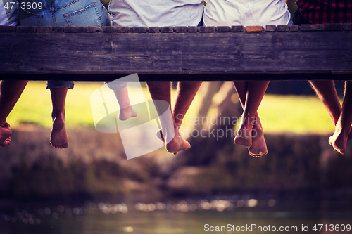 Image of people sitting at wooden bridge