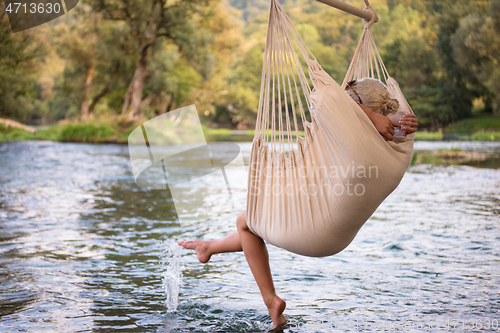 Image of blonde woman resting on hammock